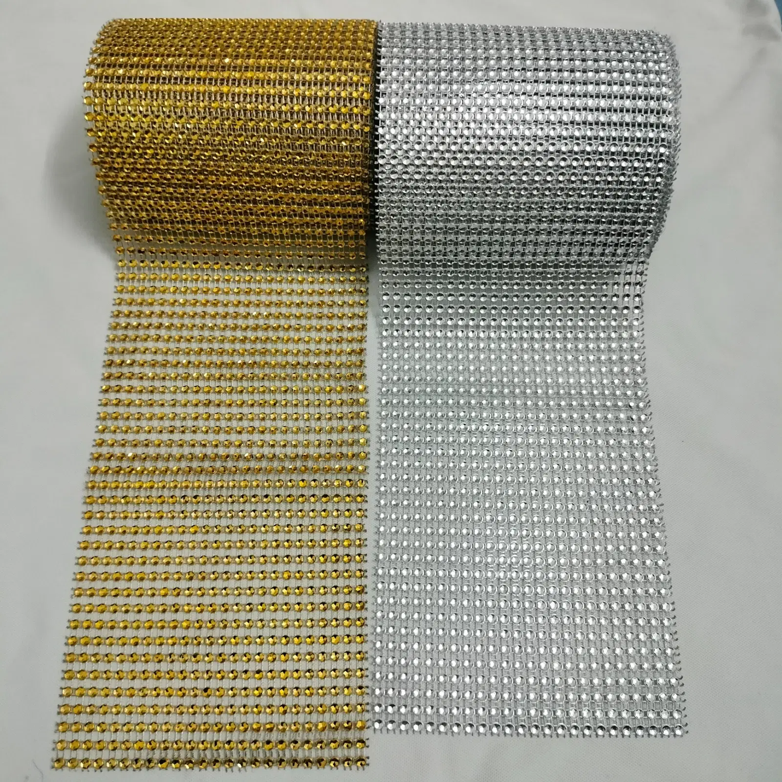 Gold and silver rhinestone mesh rolls laid flat on a white background