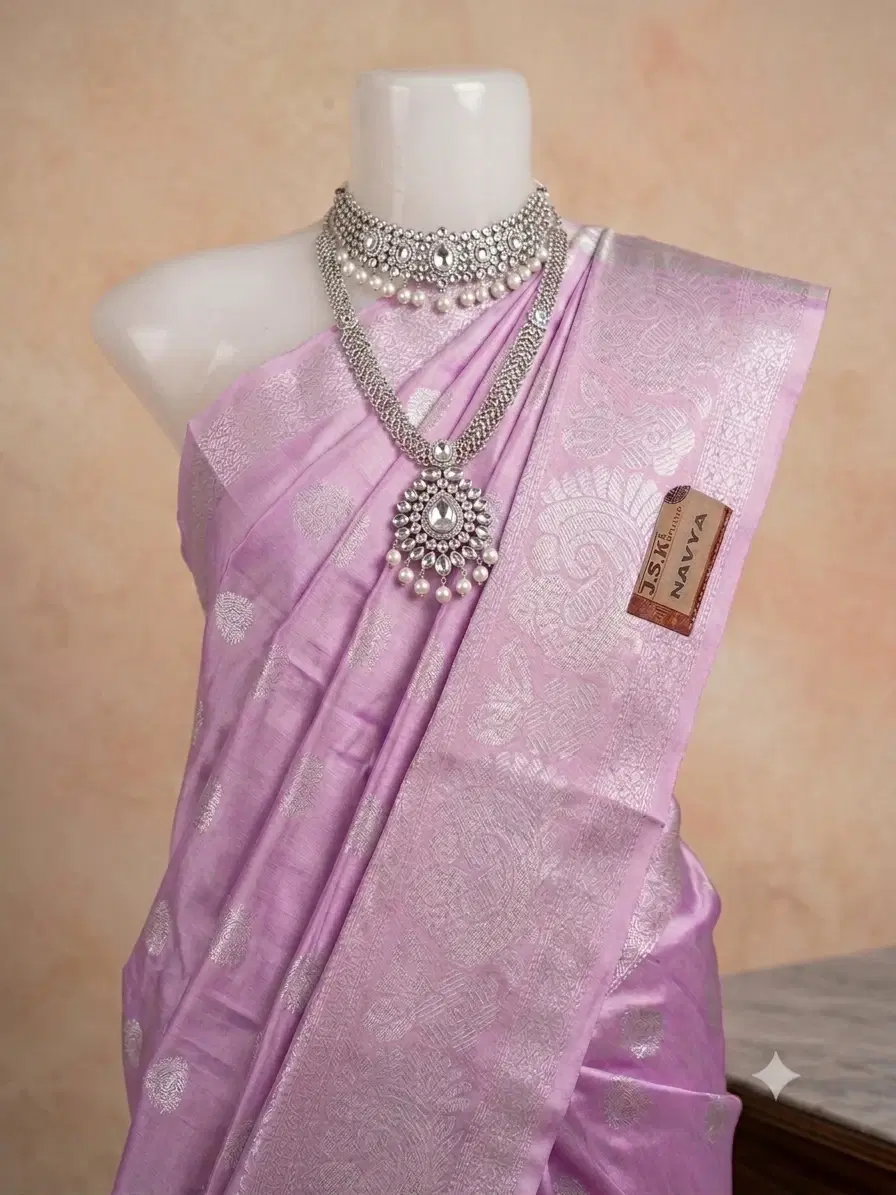 Lavender silk saree with silver woven border and motifs draped on mannequin with statement necklace