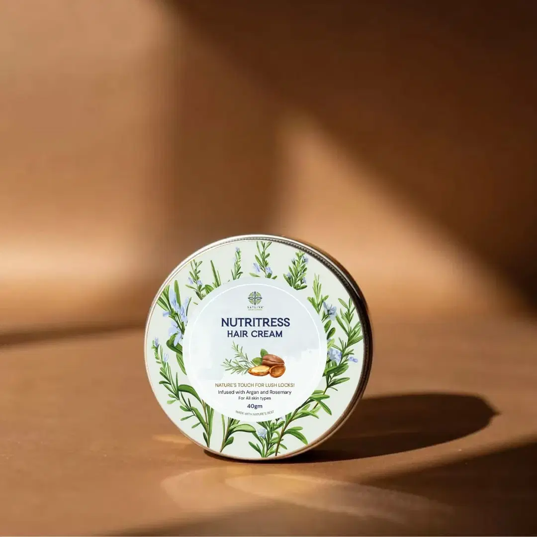 Round tin of Satliva Nutritress Hair Cream with argan and rosemary on a warm brown background