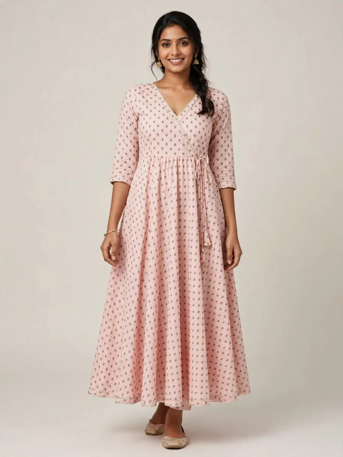 Woman wearing a pink printed wrap-style Anarkali dress with 3/4 sleeves and tie-up waist
