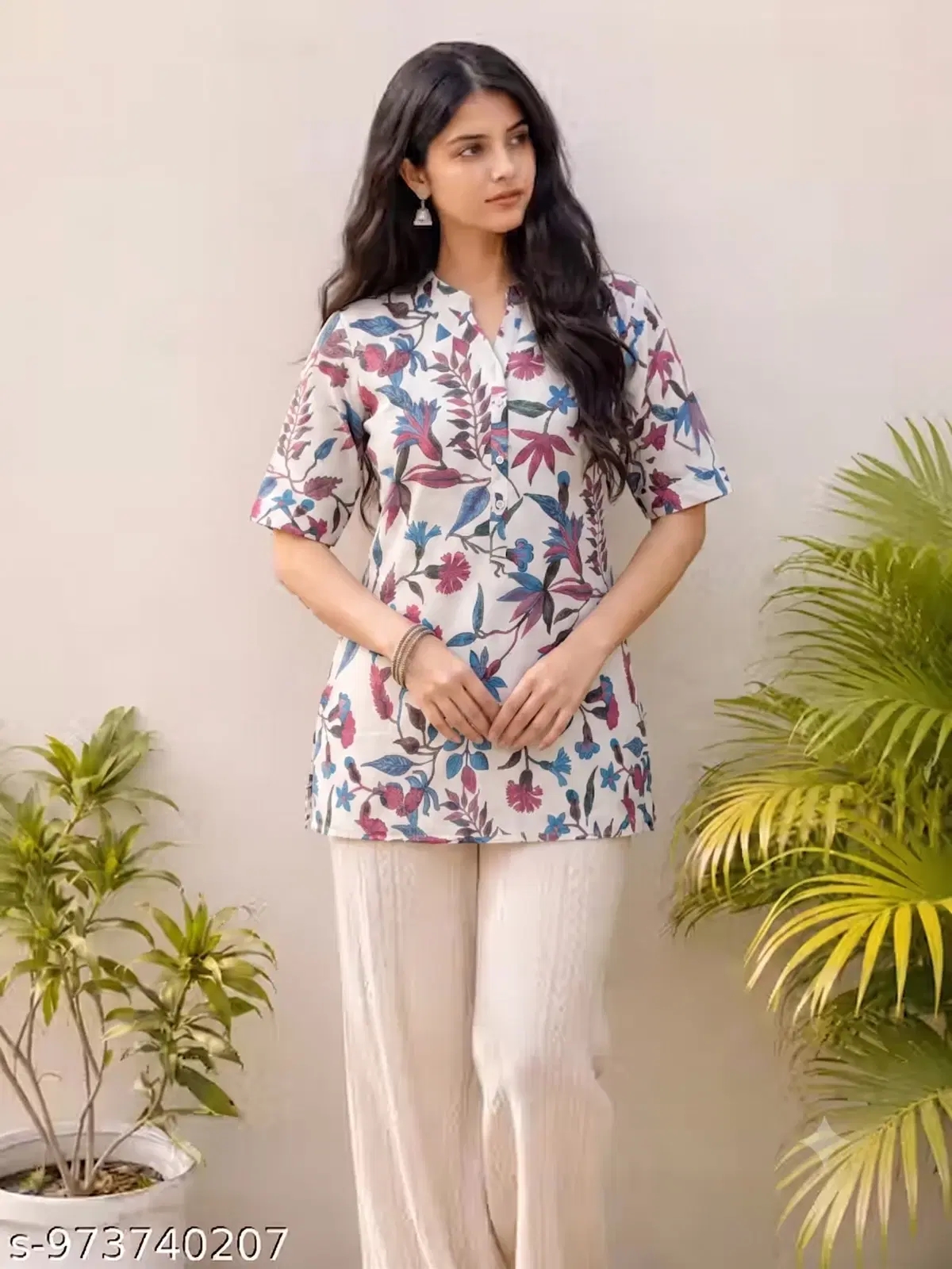 Woman wearing a white floral print short kurti tunic with short sleeves and cream trousers