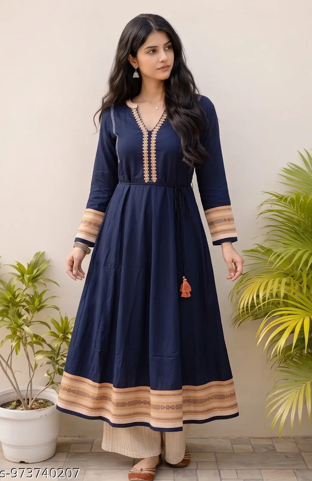Woman wearing a navy blue embroidered Anarkali kurta with beige border and tassel tie-up