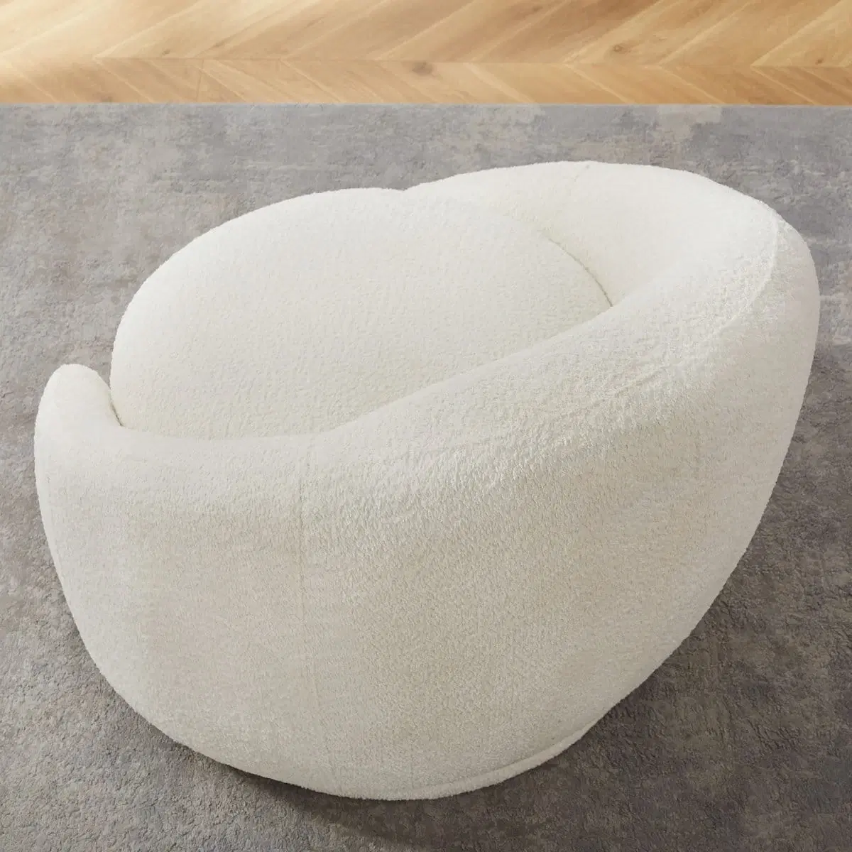 Cream boucle barrel accent chair shown at an angled top-front view on a gray rug