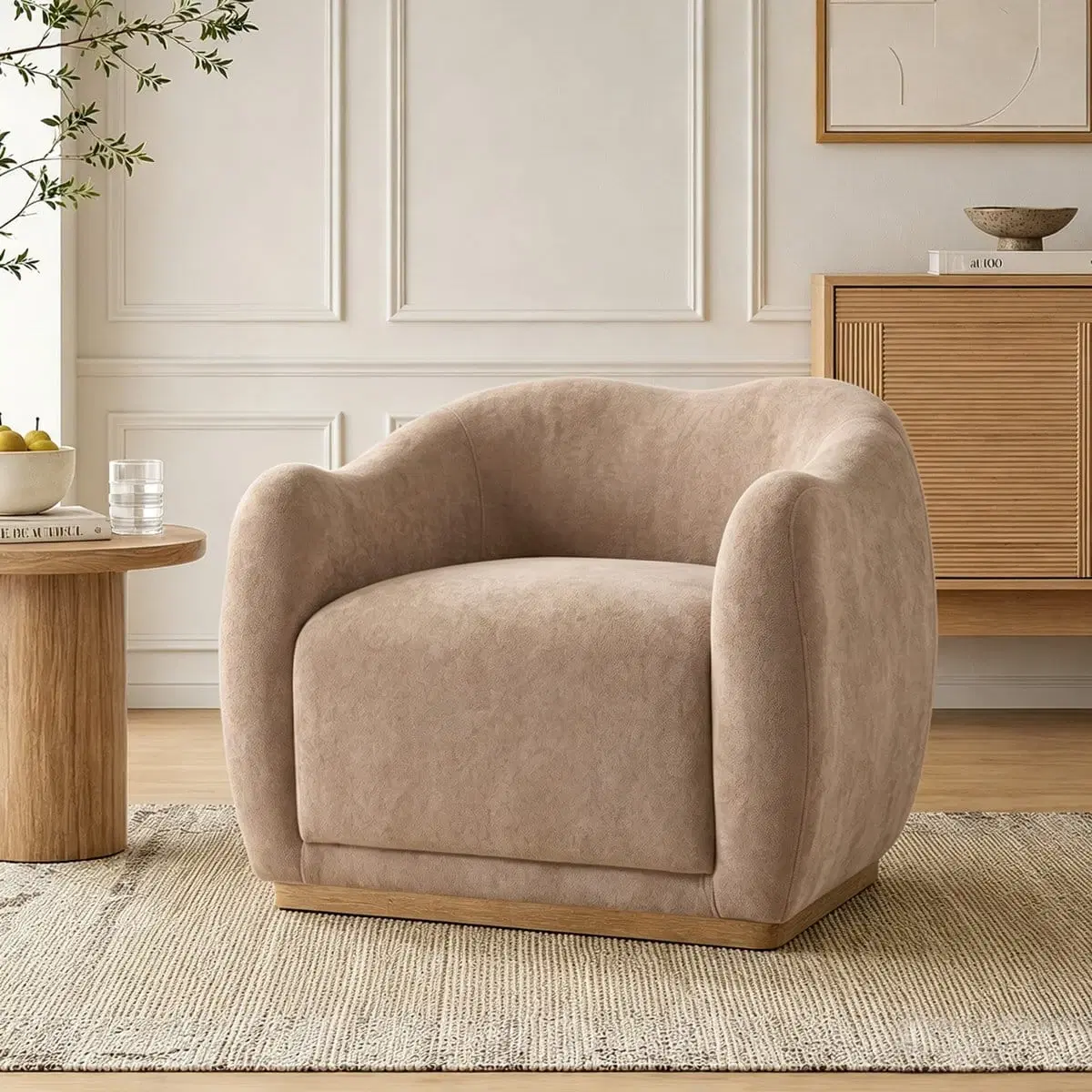 Front three-quarter view of a beige curved armchair with soft upholstery and a wood-look base