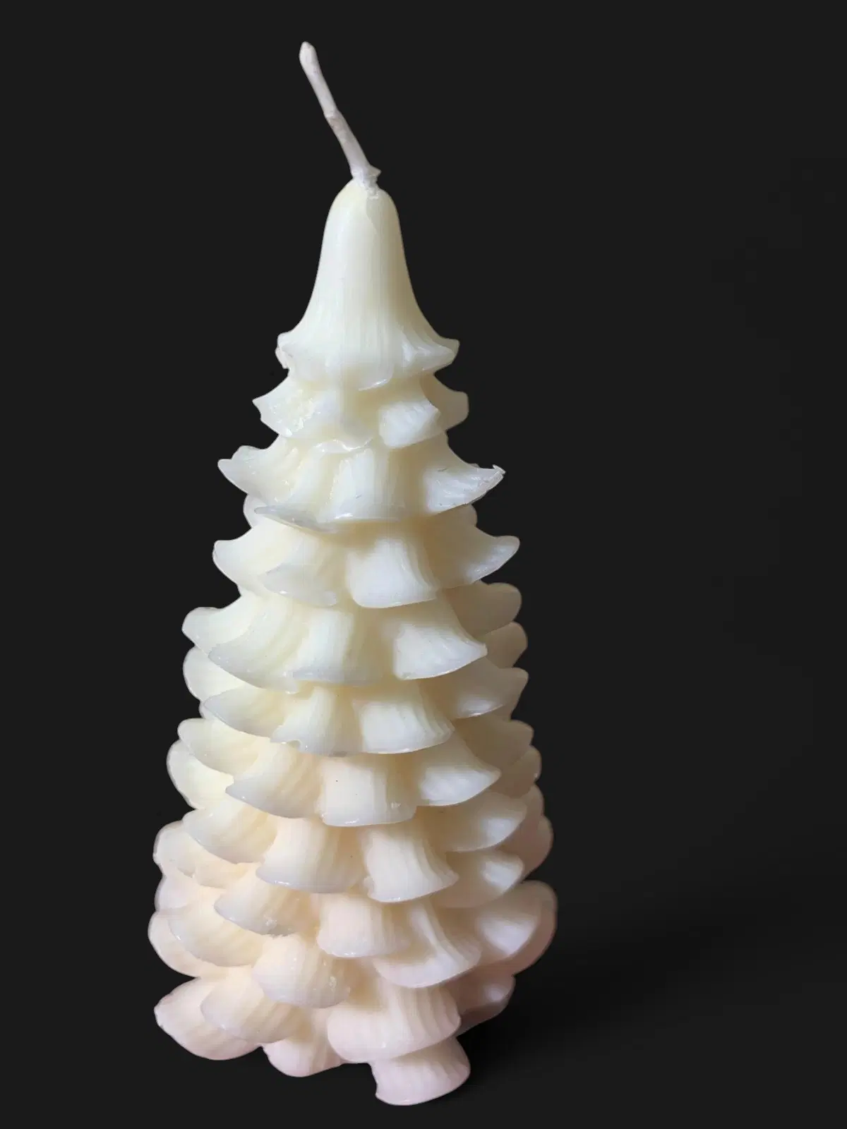 Side view of the white tree candle showing raised branch tiers and long exposed wick