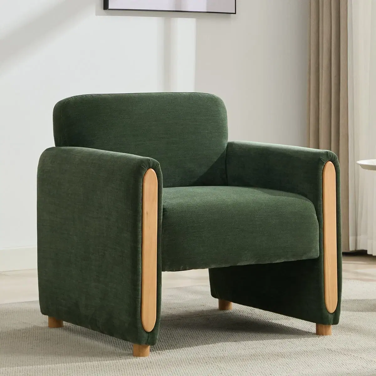 Front three-quarter view of green chenille armchair with rounded arms and natural wood side panels