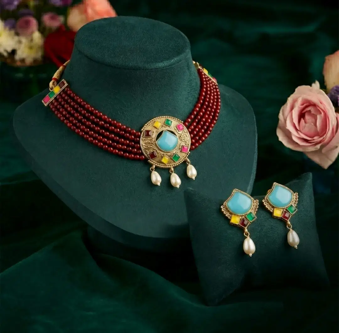 Maroon multi-strand choker set on display stand with blue pendant center and matching pearl drop earrings
