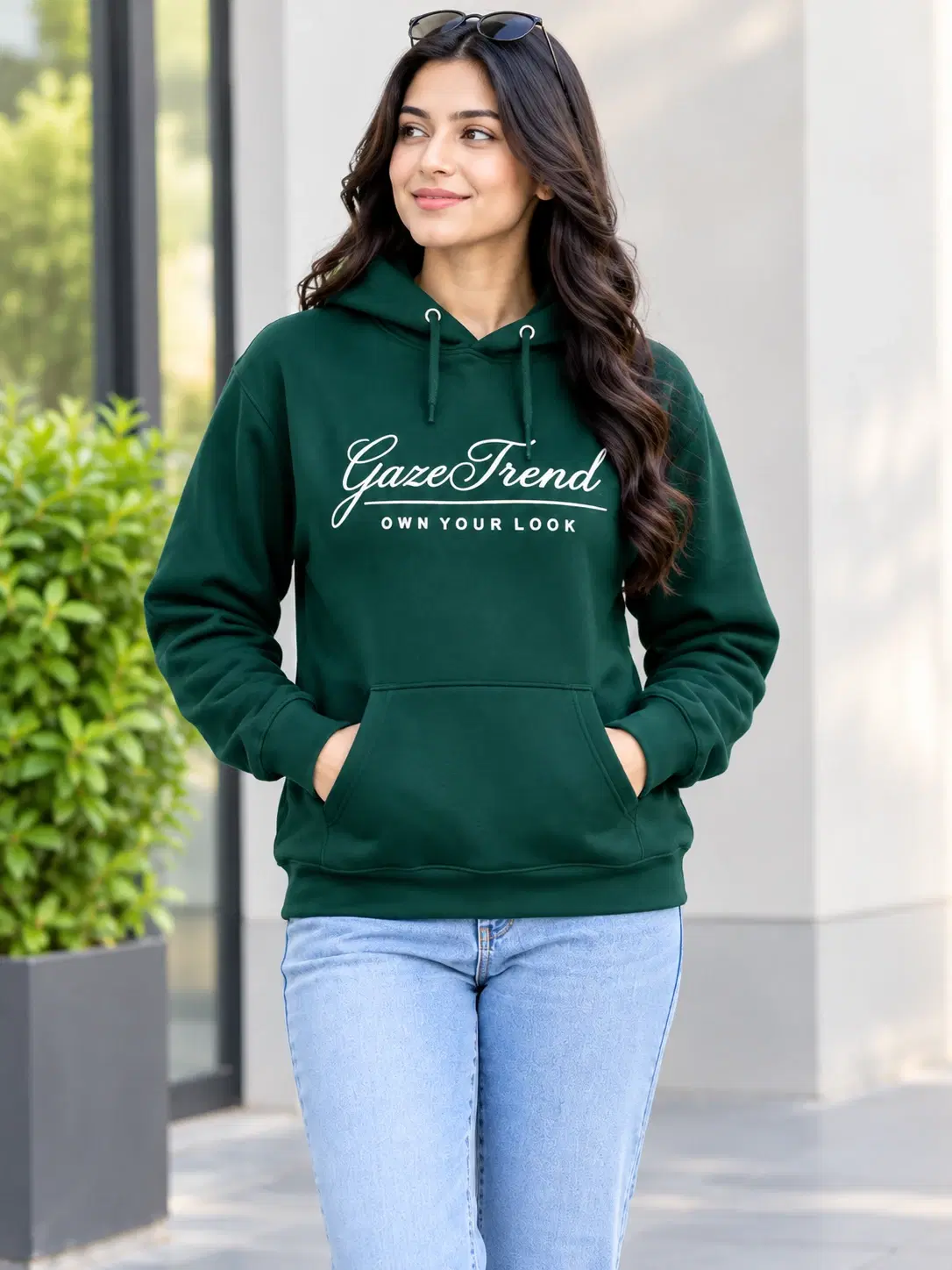 Front view of dark green Gazetrend hoodie with kangaroo pocket and drawstring hood on model