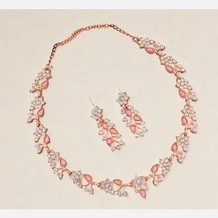 Necklace set laid flat with matching drop earrings, rose gold tone with pink stones and crystal floral links