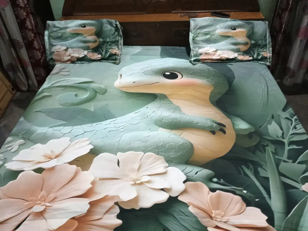 Double bed dressed in green dinosaur-print bedsheet with matching pillow covers and floral design