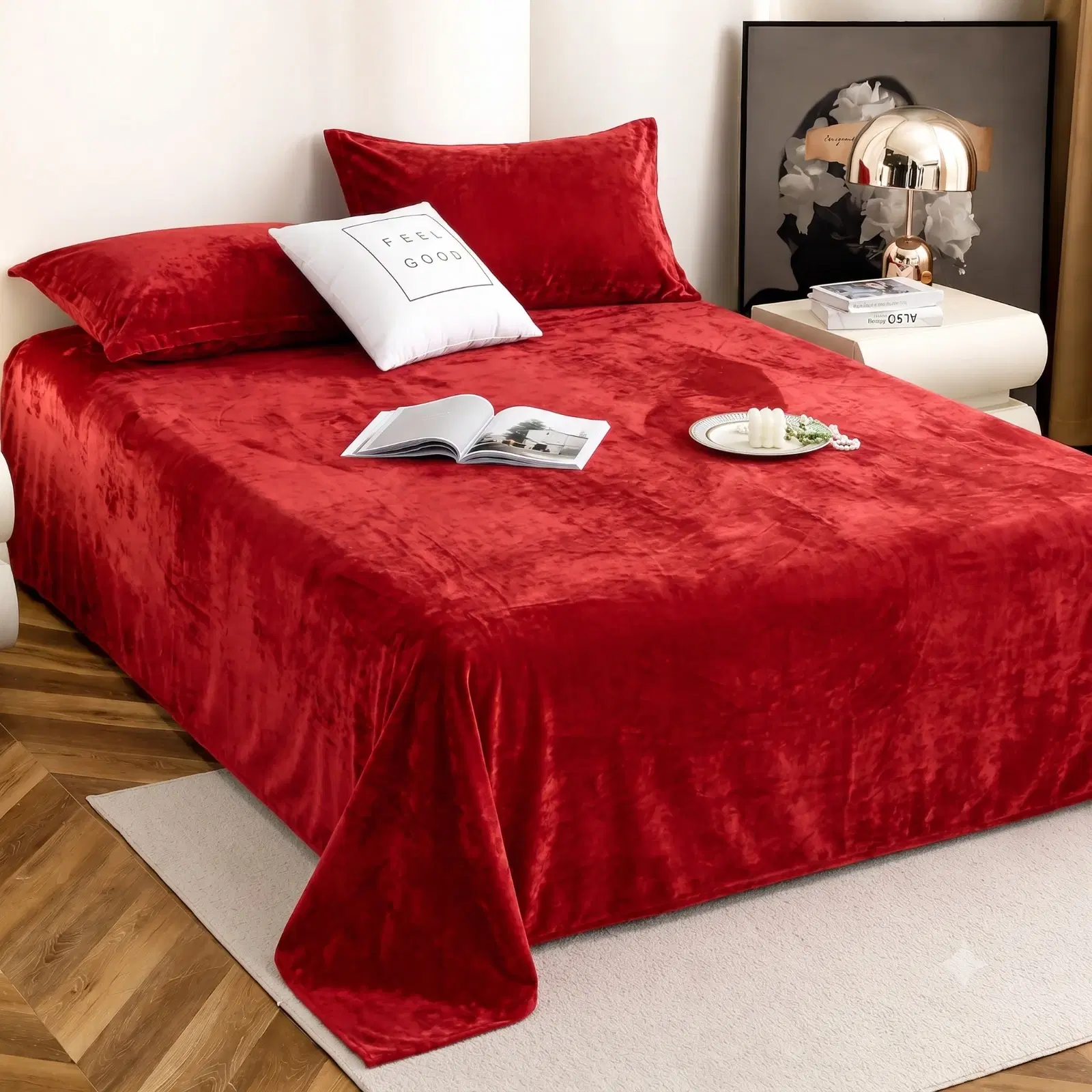 Angled bedroom view of a red velvet bedspread with two matching pillow covers on a made bed