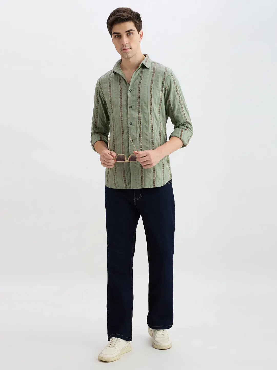 Full-body styling view with the shirt paired with dark jeans and white sneakers
