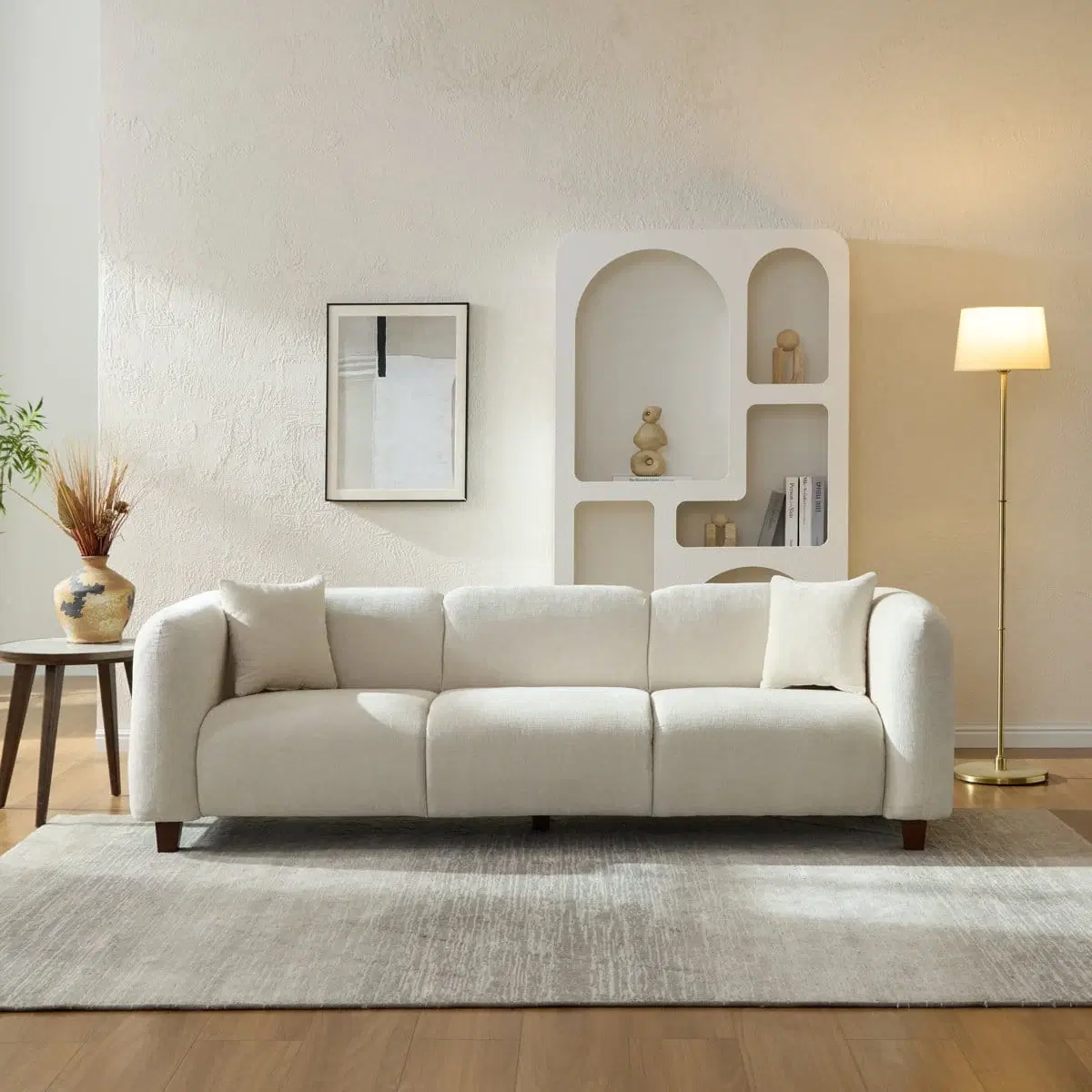 Front view of ivory 3-seater sofa styled in a living room with two accent pillows