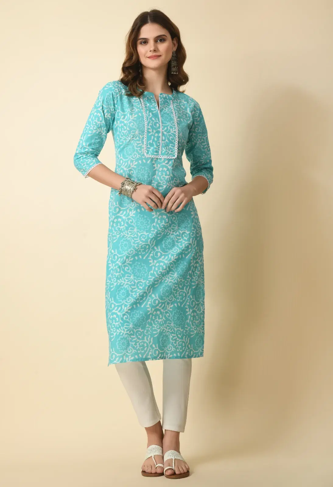 Front view of turquoise printed straight kurta with white lace-trim neckline and three-quarter sleeves