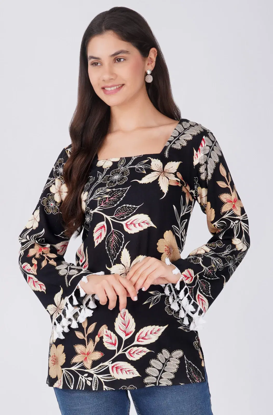 Front view of black floral top with square neckline and white tassel-trimmed bell sleeves