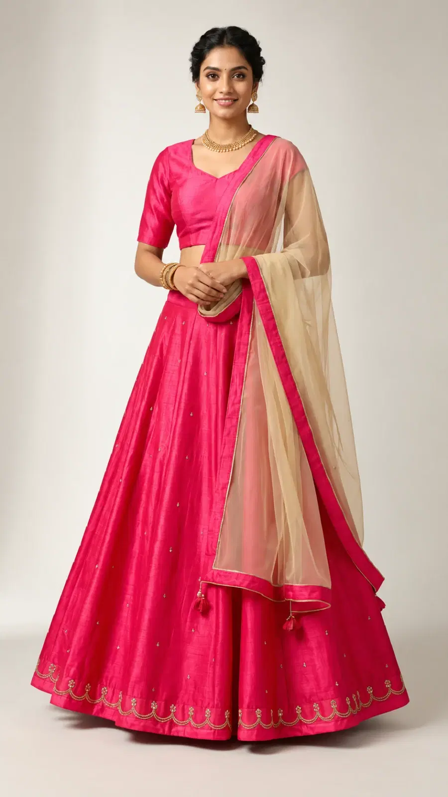 Front view of pink lehenga set with short-sleeve blouse and beige net dupatta with pink border