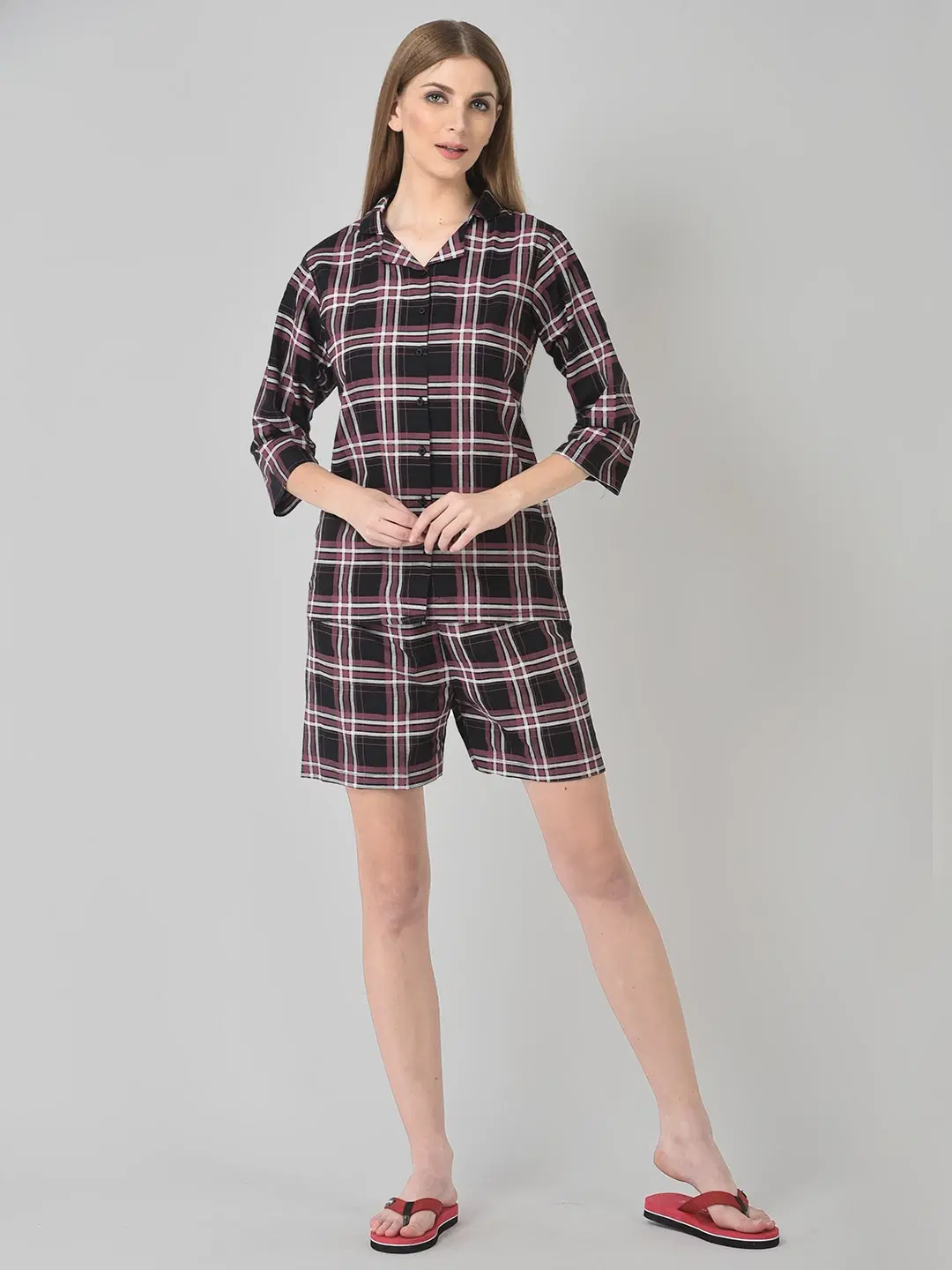 Front full-body view of a model wearing a maroon plaid collared shirt with matching knee-length shorts