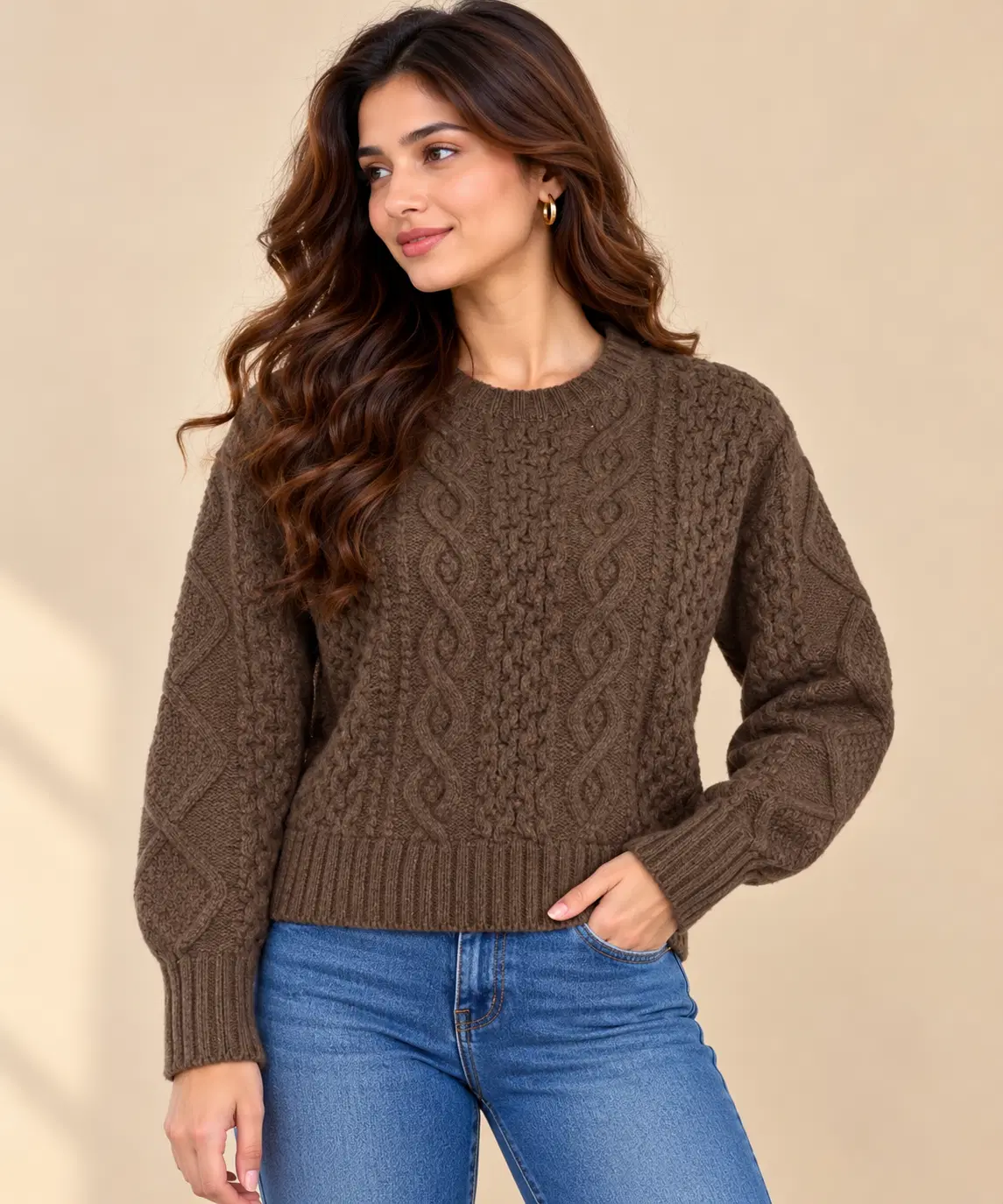 Front three-quarter view of a brown cable knit crew neck sweater with ribbed hem and cuffs