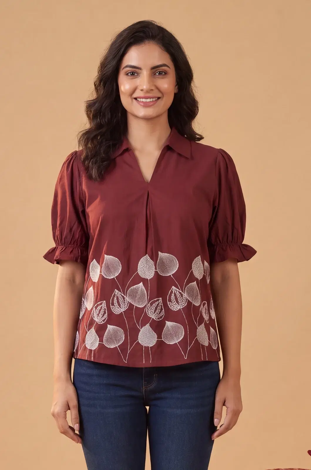 Women’s maroon puff sleeve top with collar and white leaf print, paired with blue jeans