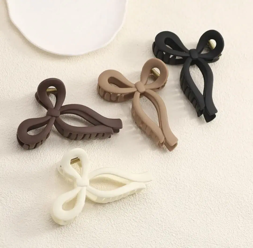 Pack of matte bow hair claw clips in neutral multicolor shades.