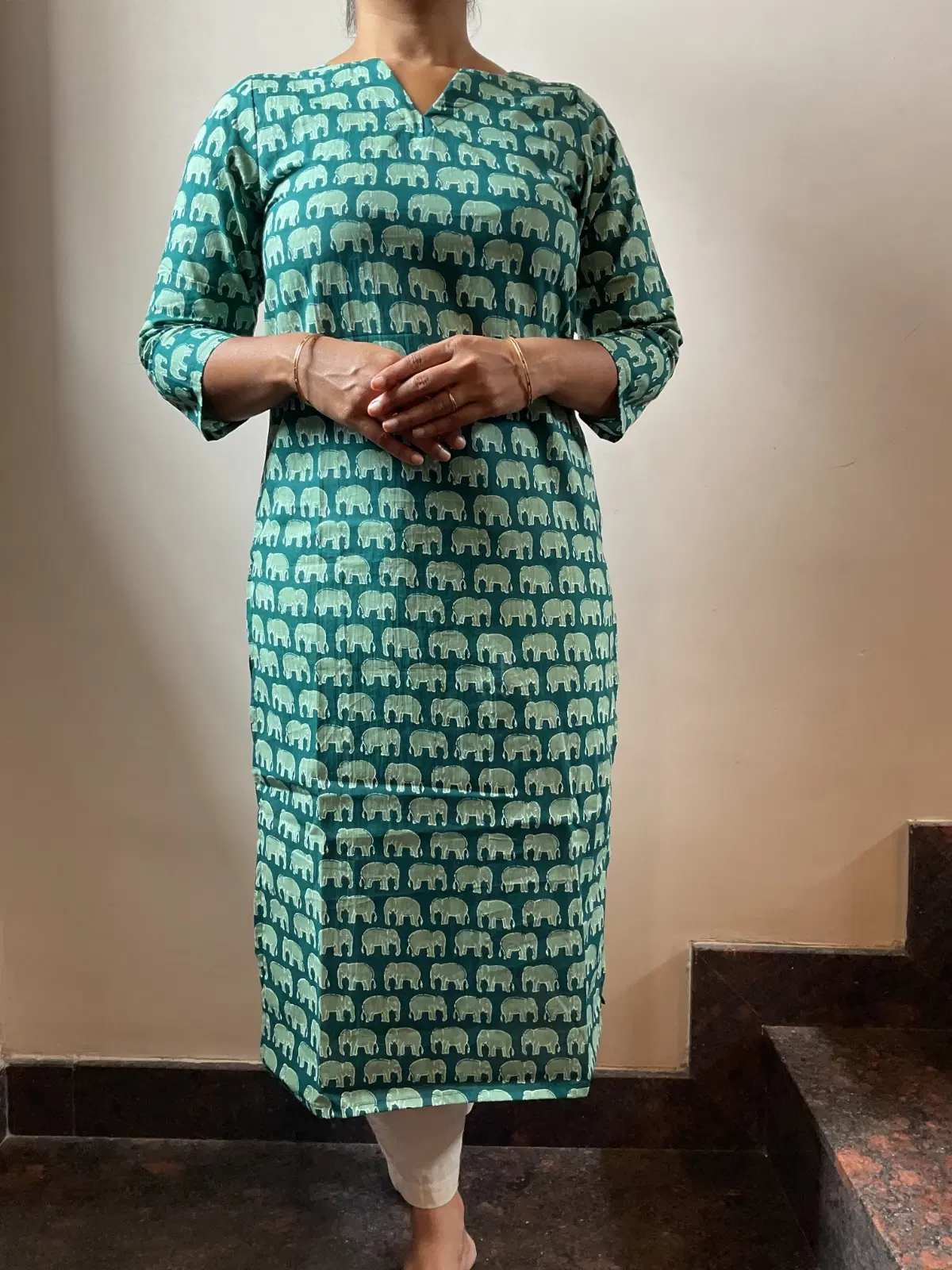 Woman wearing a teal straight kurta with white elephant print and three-quarter sleeves