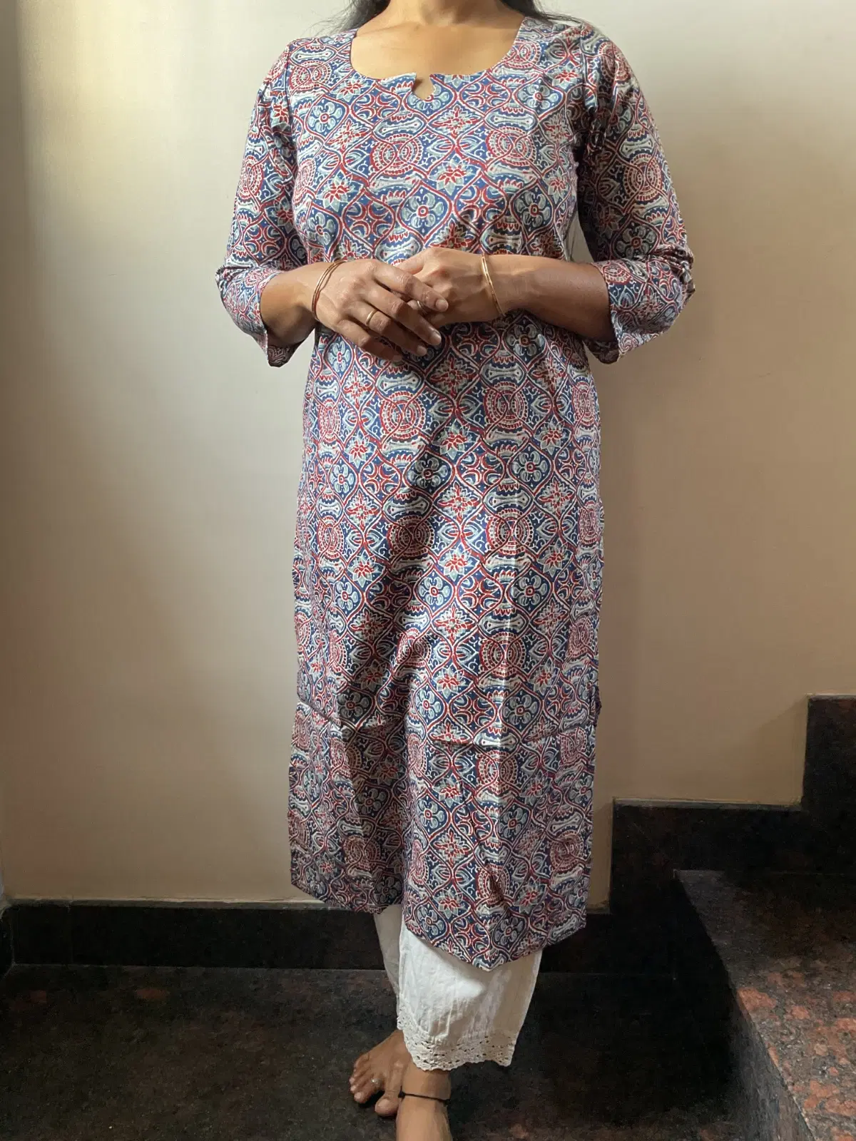 Woman wearing a blue and red printed straight kurta with 3/4 sleeves and white pants