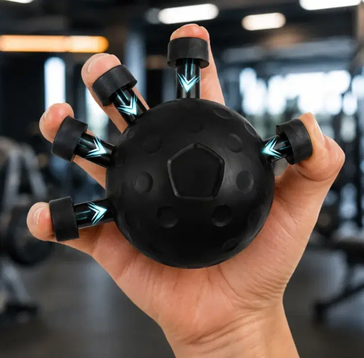 Hand holding a black finger exerciser ball with five spring-loaded finger grips